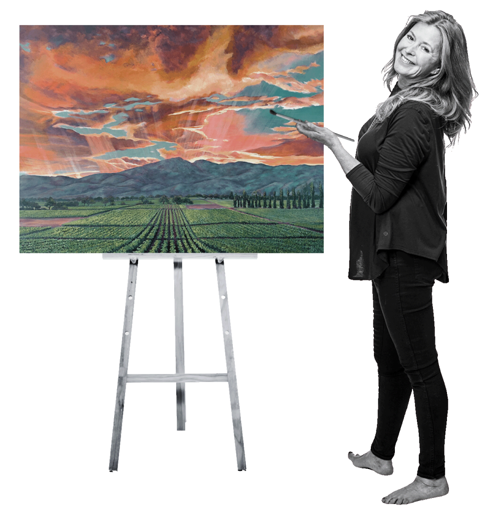 Darcie Kent standing at an easel holding an original painting of the vineyards at Darcie Kent Estate Vineyards