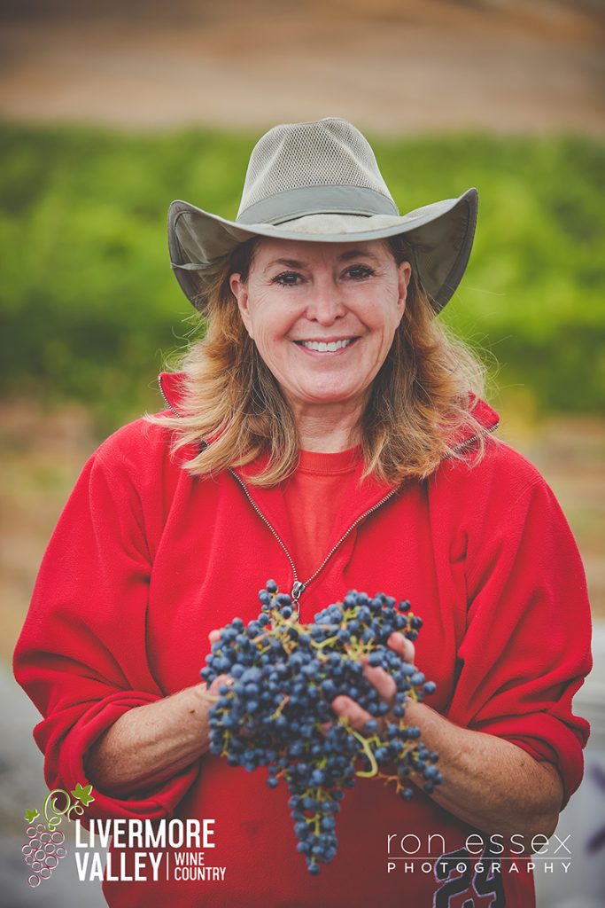 Darcie holding grapes at harvest time (please credit Ron Essex if watermark is cropped)	